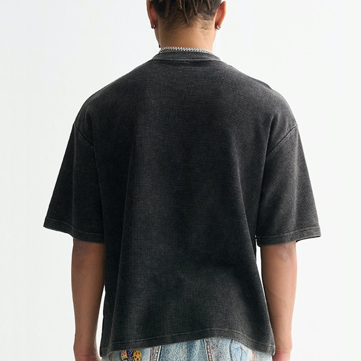Person wearing a black t-shirt on a plain background