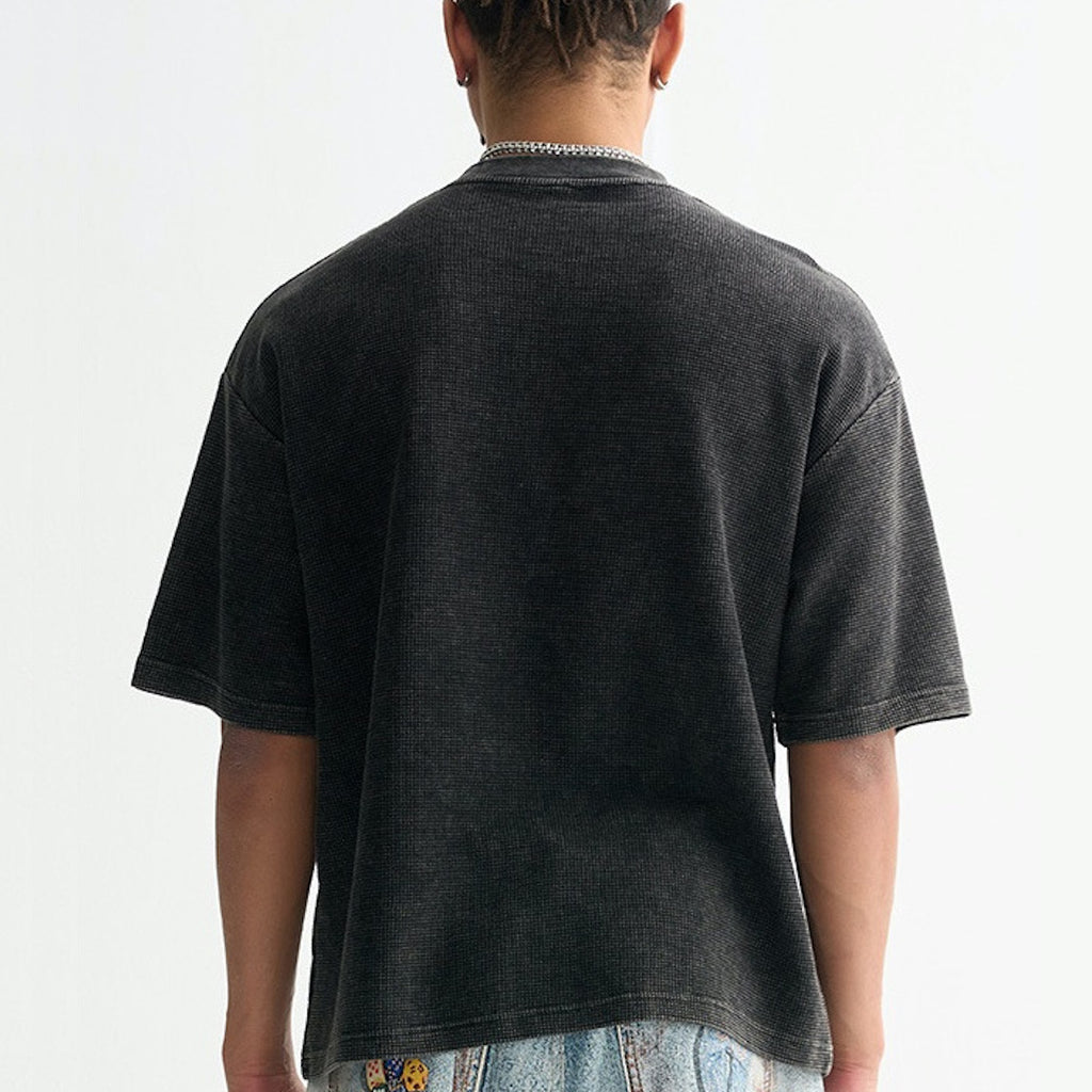 Person wearing a black t-shirt on a plain background
