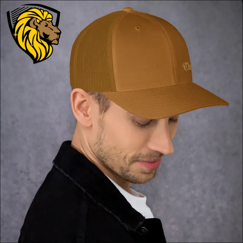 Mustard yellow trucker cap worn in profile, showcasing bold Gold The One embroidery