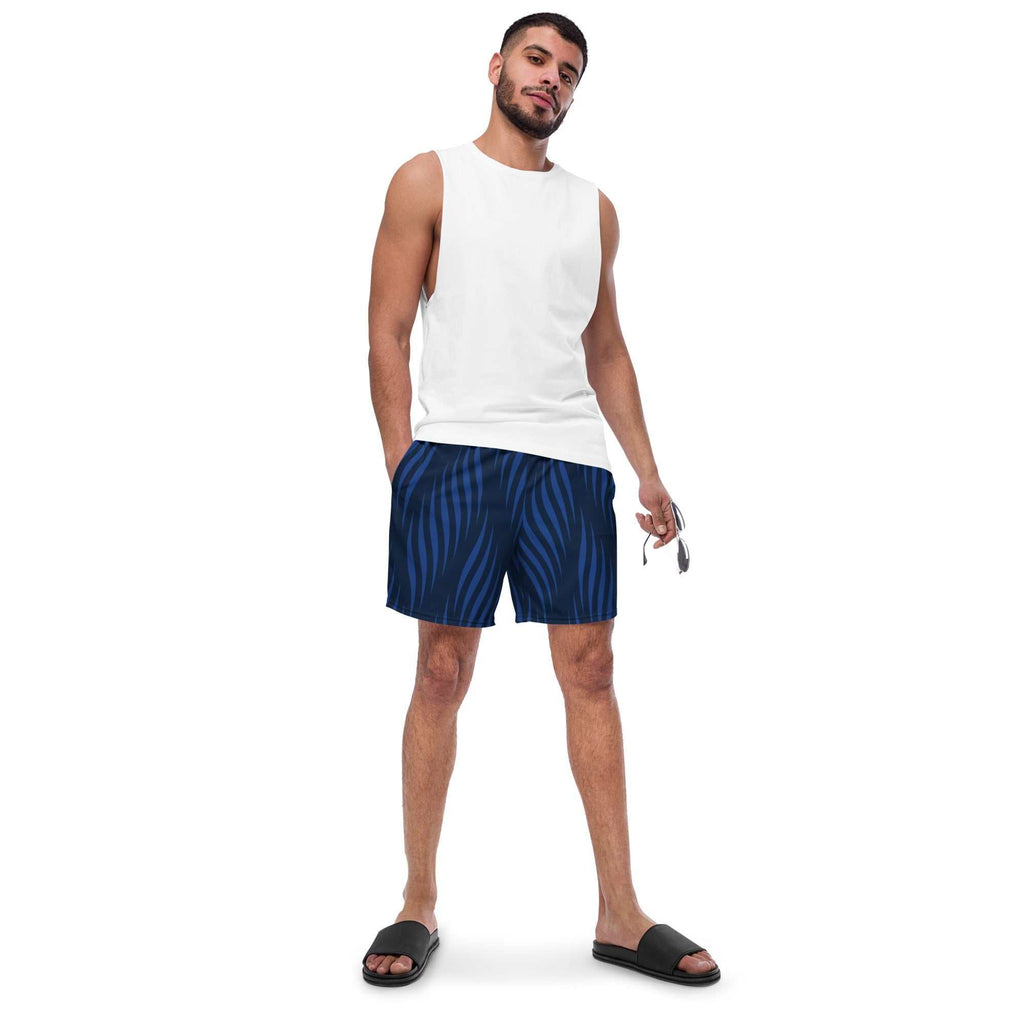Man wearing Blue Leaf Swim Trunks with eco-friendly fabric and UPF 50+ sun protection standing in casual pose.