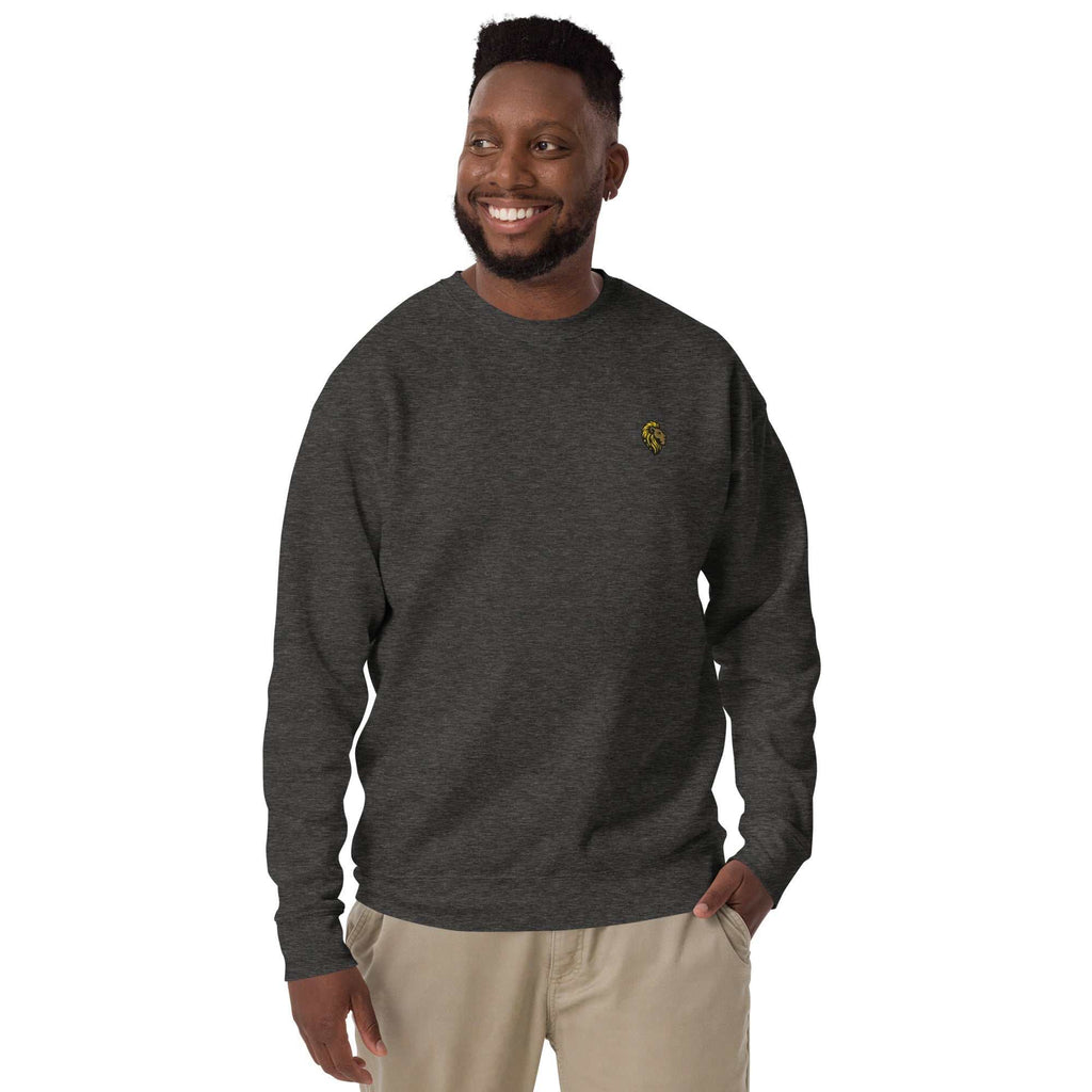 Man wearing Unisex The One Essential Sweatshirt in dark gray with a small logo, styled casually with beige pants